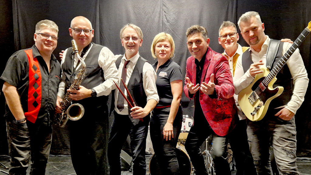 Sie brachten die Hits von Elvis auf die Kammerbühne. V.l.: Martin Panner, Andreas Schacher, Hardy Auer, Kammerbühne-Mitarbeiterin Veronika Bock, Sänger Reinhard Reiskopf, Christoph Schuster und Johannes Grill. Foto: Dieter Holzer (NÖN)